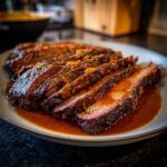 A close-up of perfectly sliced braised beef brisket, glistening with a rich sauce.