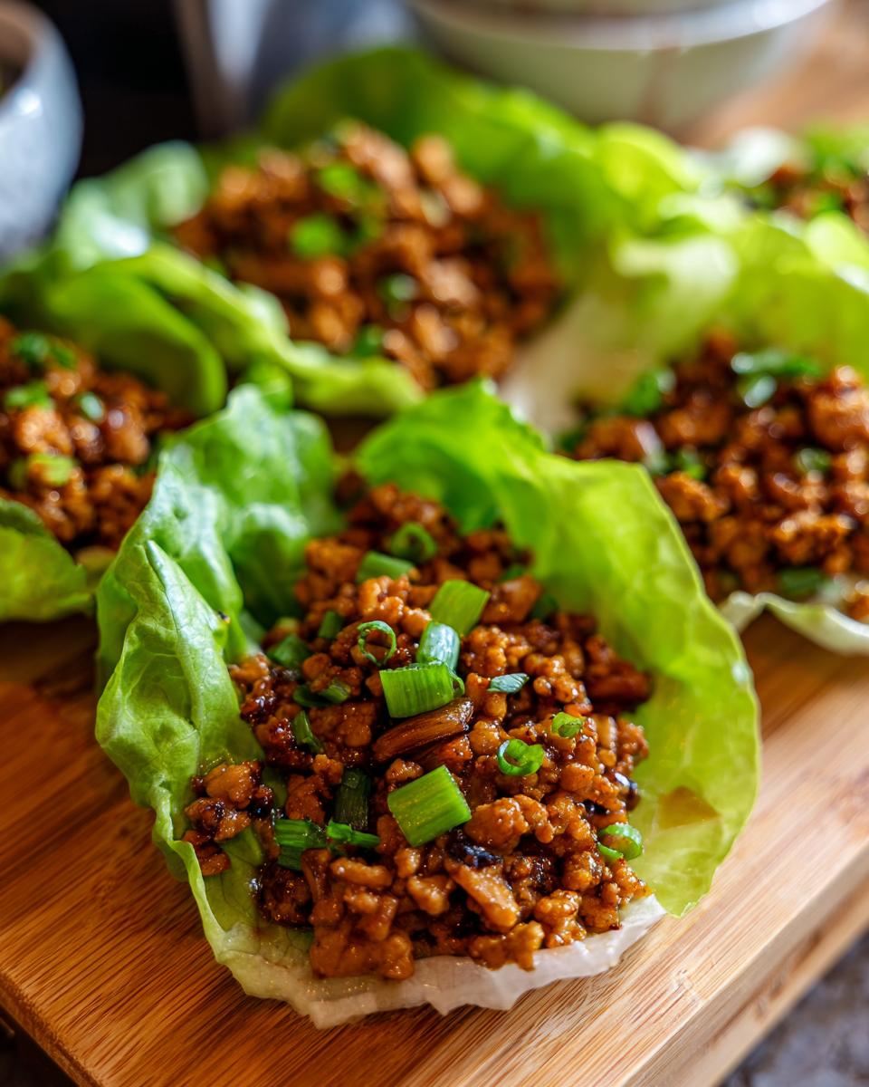 Close-up of delicious chicken lettuce wraps filled with savory ground chicken and topped with chopped green onions.