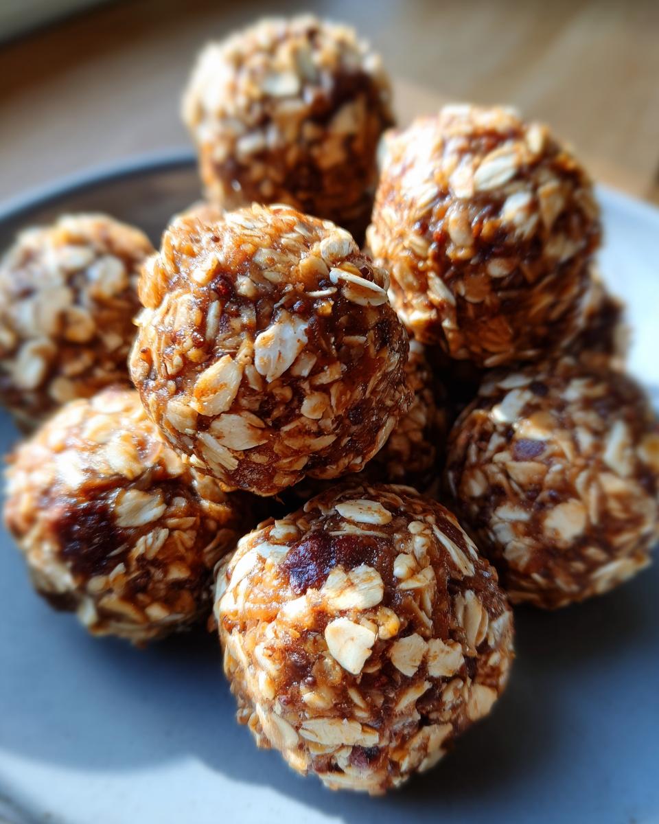 Close-up of a pile of homemade peanut butter energy balls coated in oats and dates.