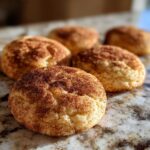 Close-up of freshly baked Snickerdoodle cookies coated in cinnamon sugar.