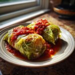 Two tender stuffed cabbage rolls topped with a rich tomato sauce, served on a plate.
