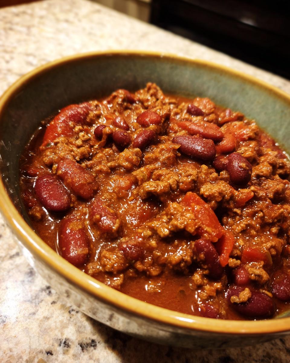 A close-up of a bowl filled with hearty Classic Beef Chili, featuring ground beef, kidney beans, and tomatoes.