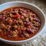 Close-up of a bowl filled with delicious classic chili, featuring ground beef, kidney beans, and a rich tomato base.