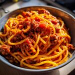 A close-up shot of a bowl filled with Instant Pot spaghetti and rich meat sauce.