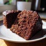 Two moist slices of decadent chocolate cake served on a light gray plate, showcasing the rich texture.