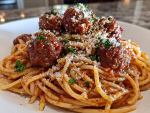A close-up of Nonna's Incredible Spaghetti and Meatballs, featuring tender meatballs in rich sauce over pasta, topped with Parmesan and parsley.