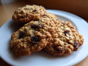 Close-up of freshly baked Oatmeal Raisin Cookies on a white plate, showcasing chewy texture and plump raisins.