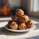 A stack of delicious Peanut Butter Oatmeal Energy Bites dotted with chocolate chips on a white plate.