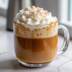 A delicious Salted Caramel Latte topped with whipped cream, caramel drizzle, and a sprinkle of sugar.