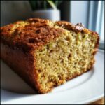 Close-up of a moist slice of amazing zucchini bread showing the golden crust and green flecks of zucchini.