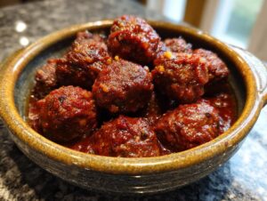 Close-up of a bowl filled with delicious cocktail meatballs coated in a rich, savory sauce.