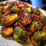 Close-up of crispy Brussels sprouts tossed with bacon bits and sprinkled with salt.