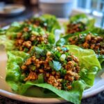 Close-up of delicious thai chicken lettuce wraps filled with savory ground chicken mixture and topped with cilantro.