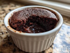 Close-up of a warm Cottage Cheese Microwave Brownie in a white ramekin with a gooey, molten chocolate center.