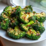 Close-up of bright green, crispy smashed broccoli florets topped with browned breadcrumbs or cheese.