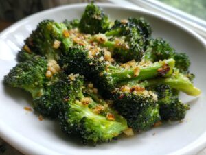 Close-up of vibrant green smashed broccoli florets topped with crispy garlic and breadcrumbs.