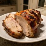 Close-up of a perfectly cooked instant pot turkey breast, sliced to show the juicy interior and browned, herb-crusted exterior.