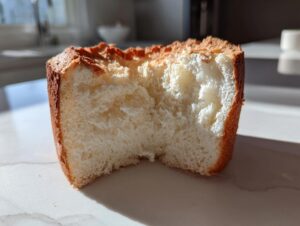 A cross-section showing the airy, white interior crumb of a freshly baked angel food cake with a golden-brown crust.