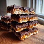 A stack of four homemade saltine cracker toffee bars with a thick chocolate topping and gooey caramel layer.