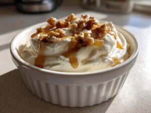 A close-up of whipped ricotta dip with hot honey drizzled over it and topped with walnuts.
