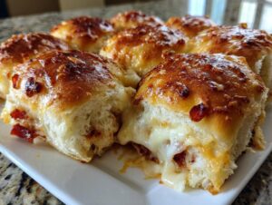 Close-up of cheesy, golden-brown pizza sliders being pulled apart, showing melted mozzarella cheese.