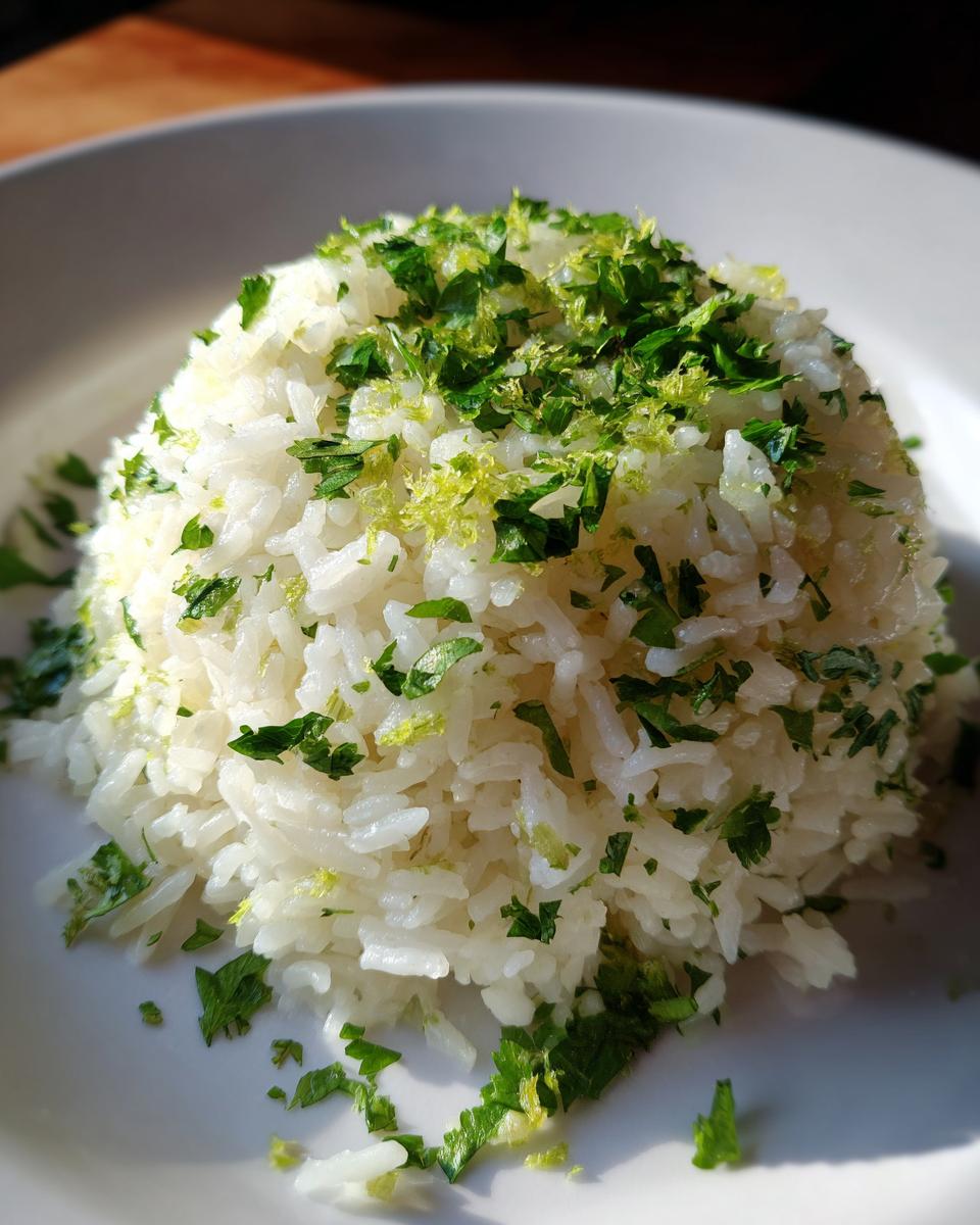 A perfectly molded serving of fluffy cilantro lime rice topped with chopped cilantro and bright green lime zest.