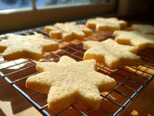 Close-up of freshly baked, star-shaped vegan sugar cookies sprinkled with sugar, cooling on a wire rack.