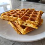 A stack of two golden brown cottage cheese waffles low carb on a white plate.