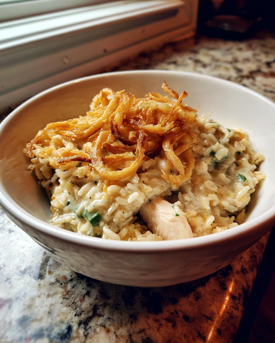 A bowl of creamy garlic chicken wild rice casserole topped with crispy fried onions.