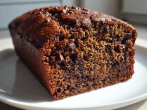 Close-up of a moist slice of double chocolate banana bread showing rich brown color and chocolate chips.