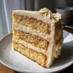 Close-up of a moist slice of three-layer earl grey lavender cake with creamy frosting between layers.