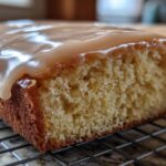 A close-up view showing the soft, moist crumb of maple donut bars topped with a thick, dripping maple glaze.