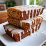 Three soft baked maple donut bars stacked on a white plate, dripping with thick white maple glaze.