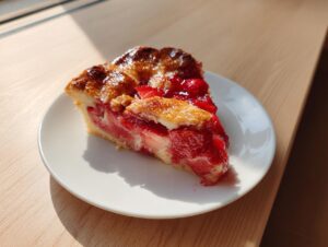 A close-up slice of an easy strawberry galette featuring a flaky, golden crust and bright red strawberry filling.