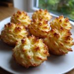 Six perfectly piped and baked duchess potatoes with golden brown, crispy edges served on a white plate.