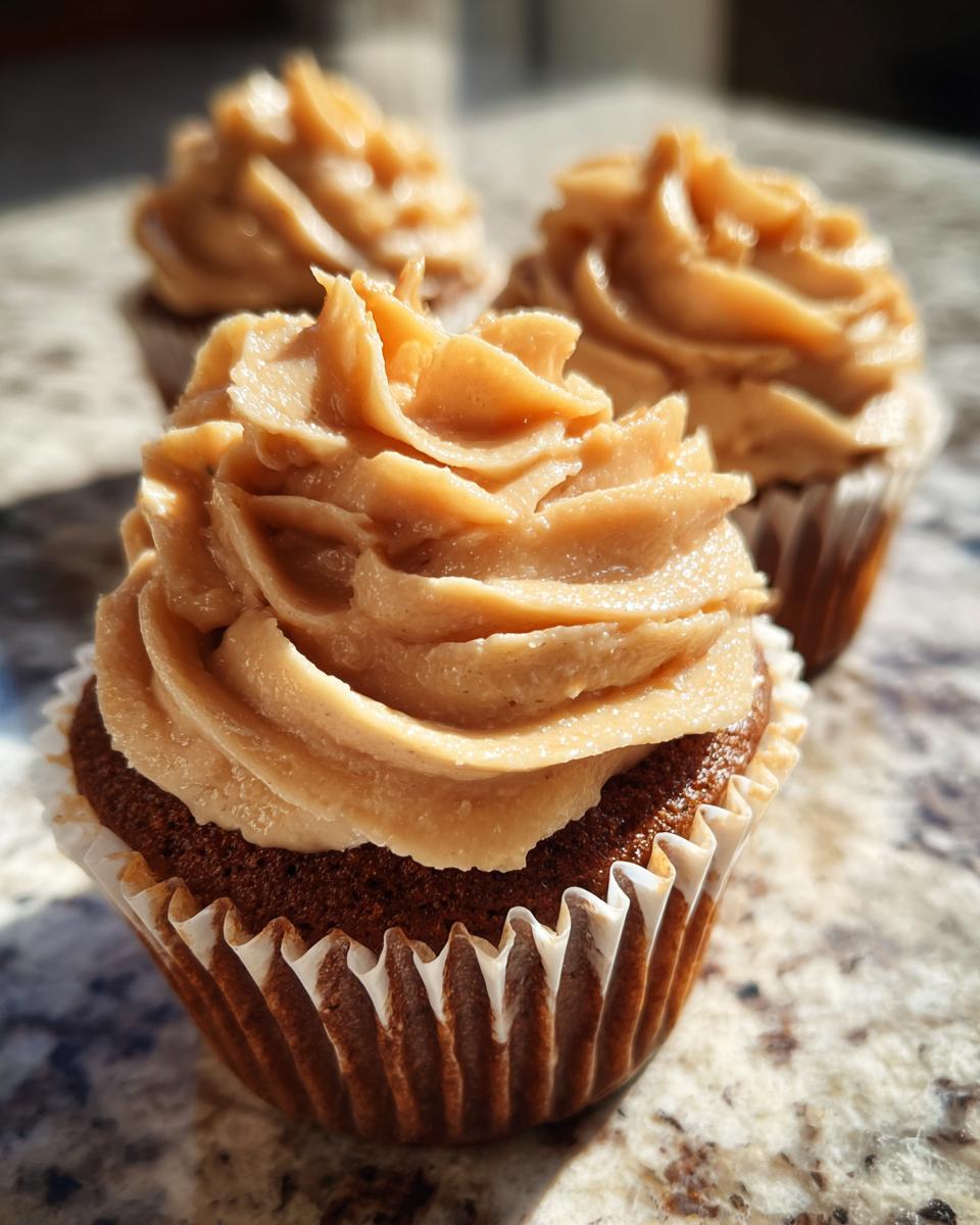 Close-up of a rich peanut butter banana cupcake topped with swirled peanut butter frosting.
