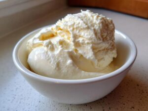 A generous scoop of thick, creamy homemade yogurt served in a small white bowl.