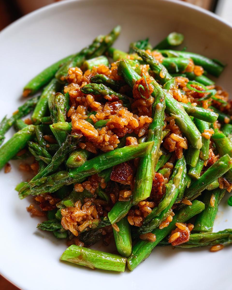 Close-up of vibrant green asparagus mixed with savory, crispy rice.